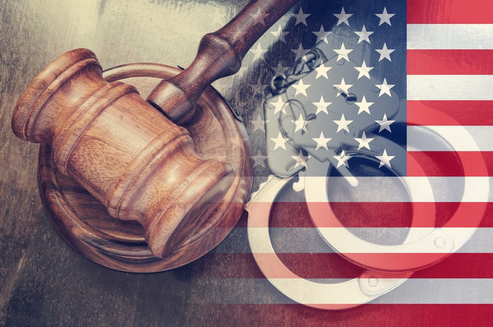 American flag image with a gavel and handcuffs in the background